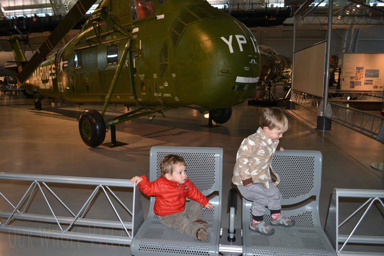 Checking out the military aircraft, or maybe just playing on chairs.